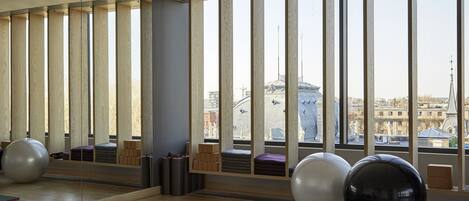A spacious room with large windows, wooden slats, and exercise balls.
