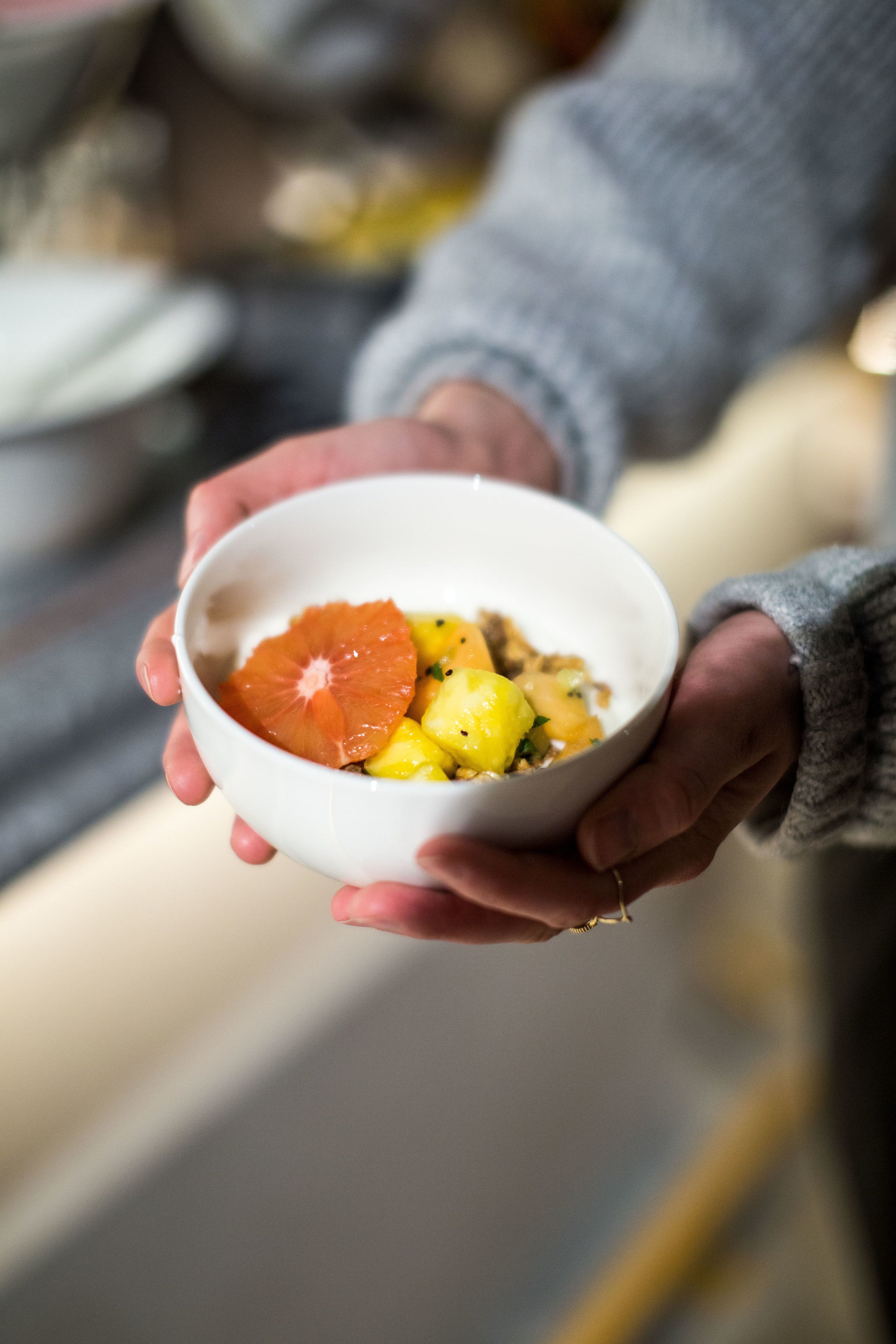 A person holding a bowl with food.