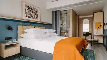 Une chambre d’hôtel comprenant un lit, une table de chevet et un bureau avec une chaise.