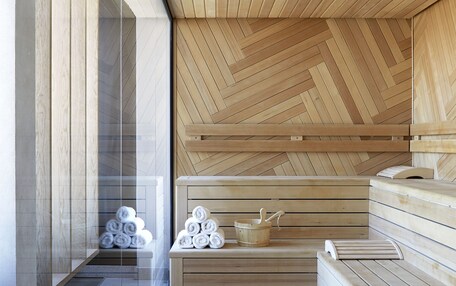 A sauna with wooden benches and a herringbone ceiling.