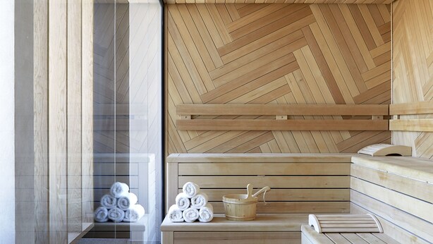 A sauna with wooden benches and a herringbone ceiling. - PURO Łódź Centrum (Lodz)