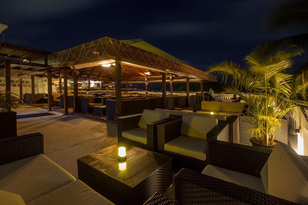 An outdoor seating area with wicker furniture and a covered section with a bar.