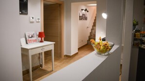 A clean, modern room with a white desk, a red lamp, and a bowl of fruit on a counter. - La Fara B&B (Benevento)
