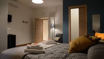 Een hotelkamer met een net opgemaakt bed, een bedlampje, een stoel en een kledingkast.