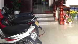 A living room with a staircase, a motorcycle, and a dining area with a table and chairs. - Quang Diep Hostel (Ho Chi Minh City)