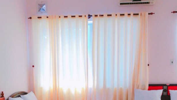 A hotel room with two beds, a window with curtains, an air conditioning unit, and a tiled floor. - Quang Diep Hostel (Ho Chi Minh City)