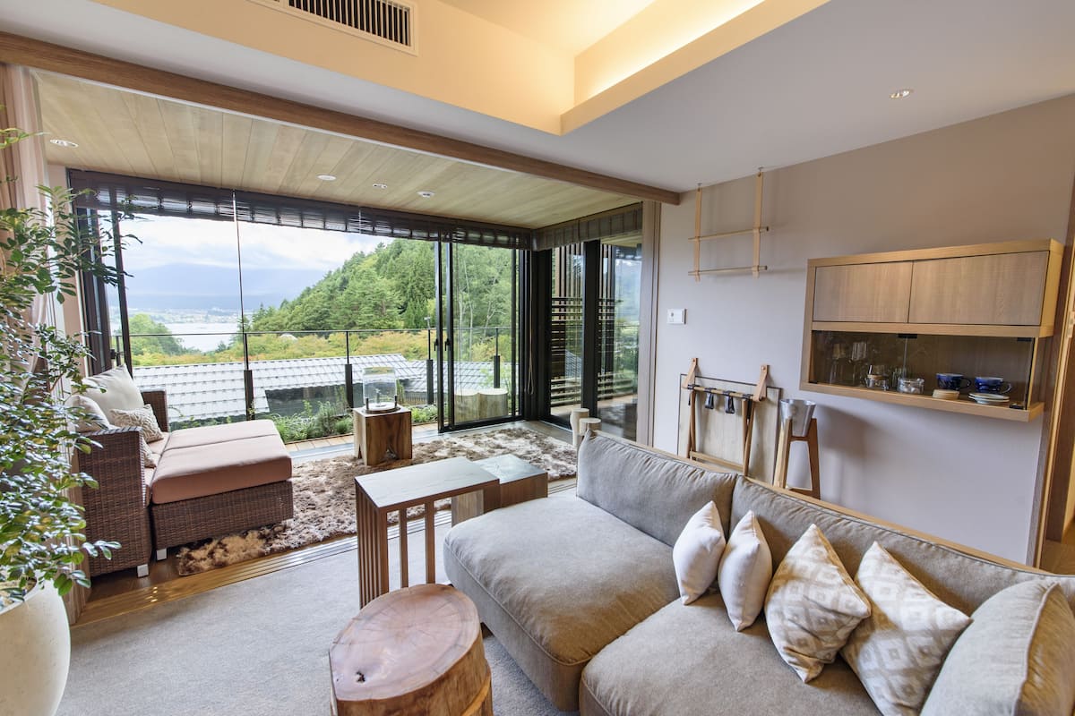 A modern living room with a sofa, coffee table, and a view of the outdoors.