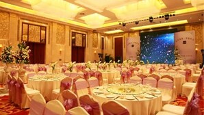 A banquet hall with round tables, pink and white chairs, and floral centerpieces. - Grand Metropark Guofeng Hotel Tangshan (Tangshan)