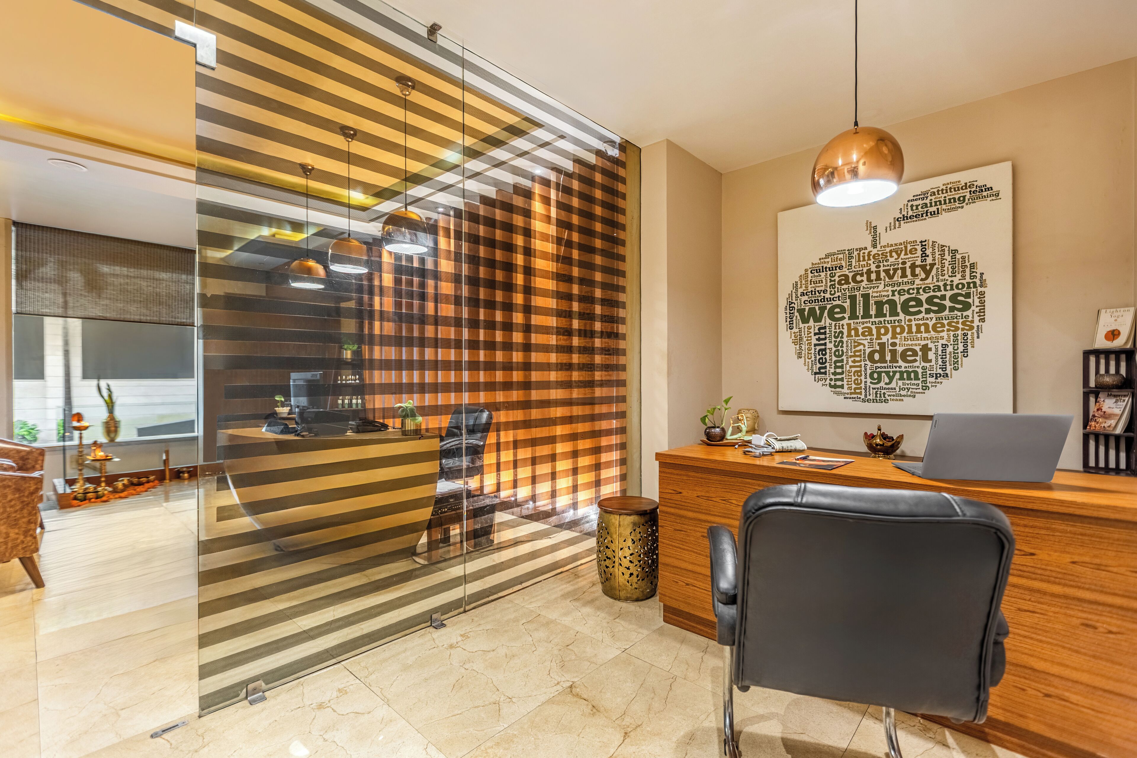 A modern office space with a reception desk, a laptop, and a word cloud poster on the wall.