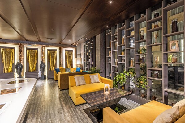A modern interior with a yellow sofa, a coffee table, and a bookshelf filled with decorative items.