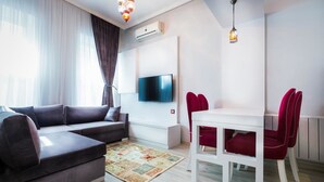 Habitación triple | Área de sala de estar | Televisión LCD
