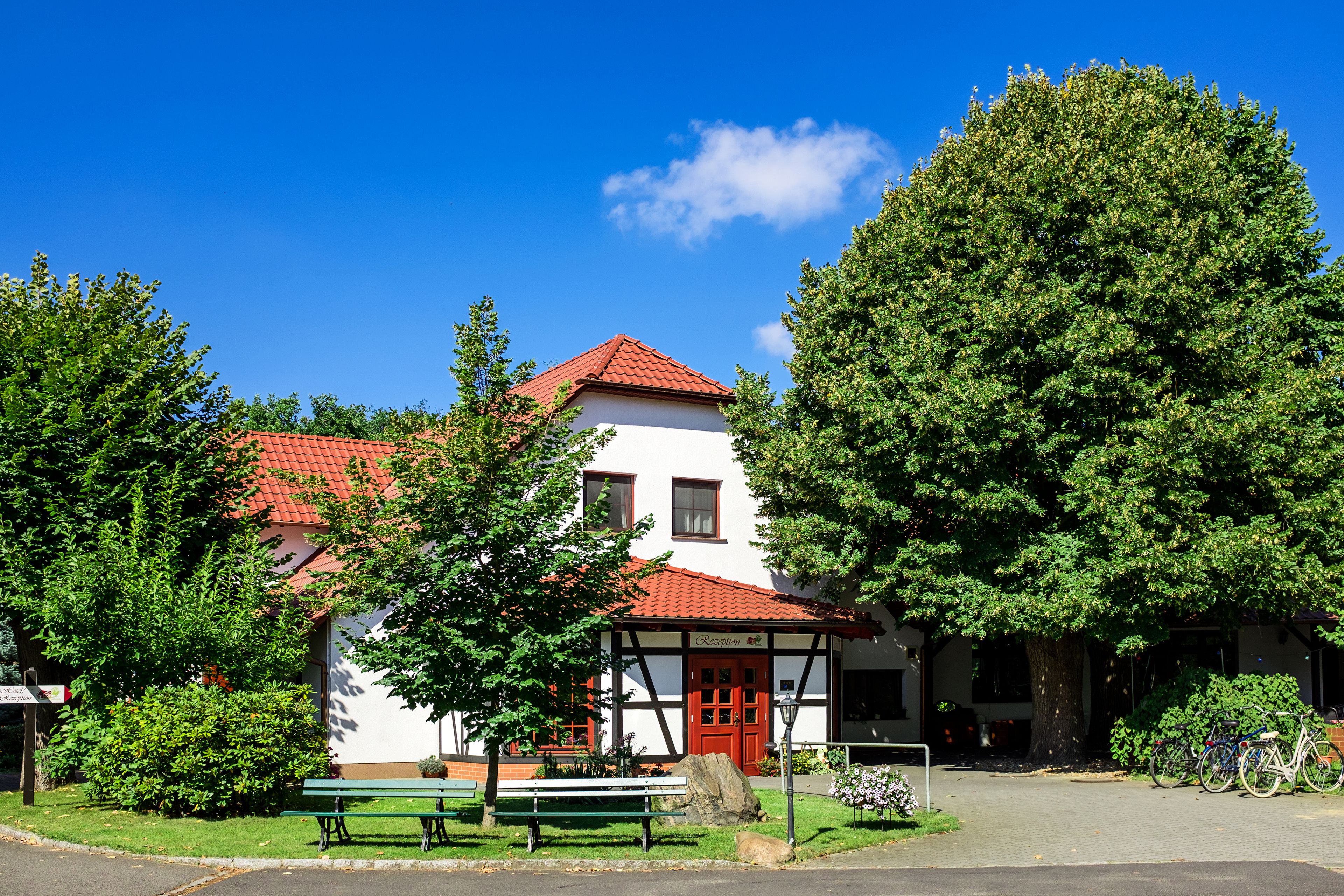 A traditional building with a red-tiled roof, a white facade, and a red door.