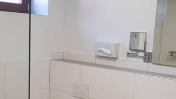 Un baño moderno con inodoro, lavabo y cabina de ducha de vidrio.