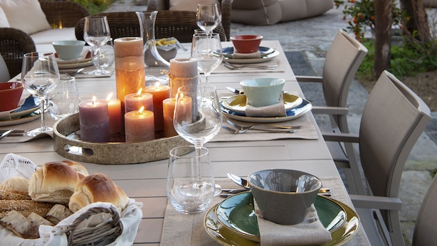 An outdoor dining area with a table set for a meal, overlooking a scenic view.