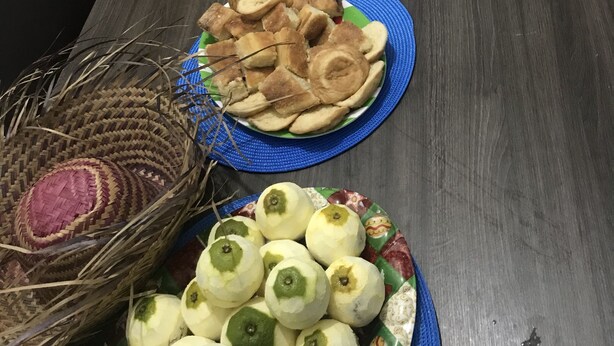 A dining table with various dishes, including corn on the cob, biscuits, and a dessert. - Pousada Axé (Salvador)
