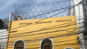 A yellow building with three arched windows and a large wooden door. - Pousada Axé (Salvador)