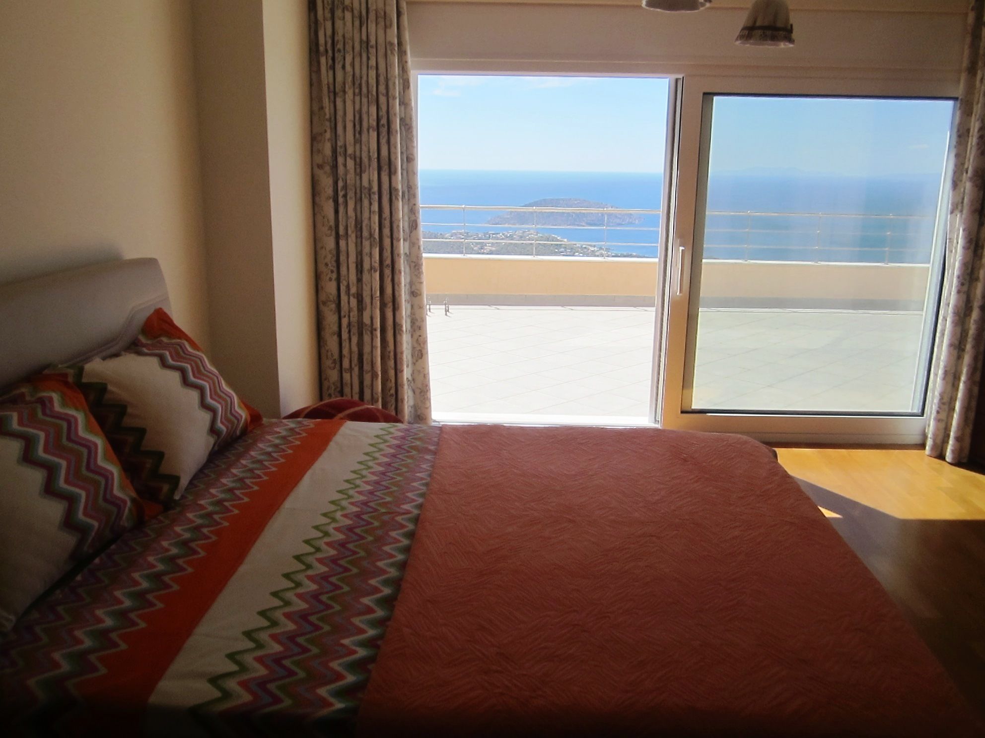 Habitación de hotel con cama, vista al mar y balcón.