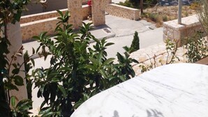 A stone building with a view of the sea and a town in the distance. - Viva B&B (Saronikos)