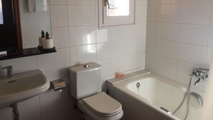 Ein Badezimmer mit Toilette, Waschbecken und Badewanne.
