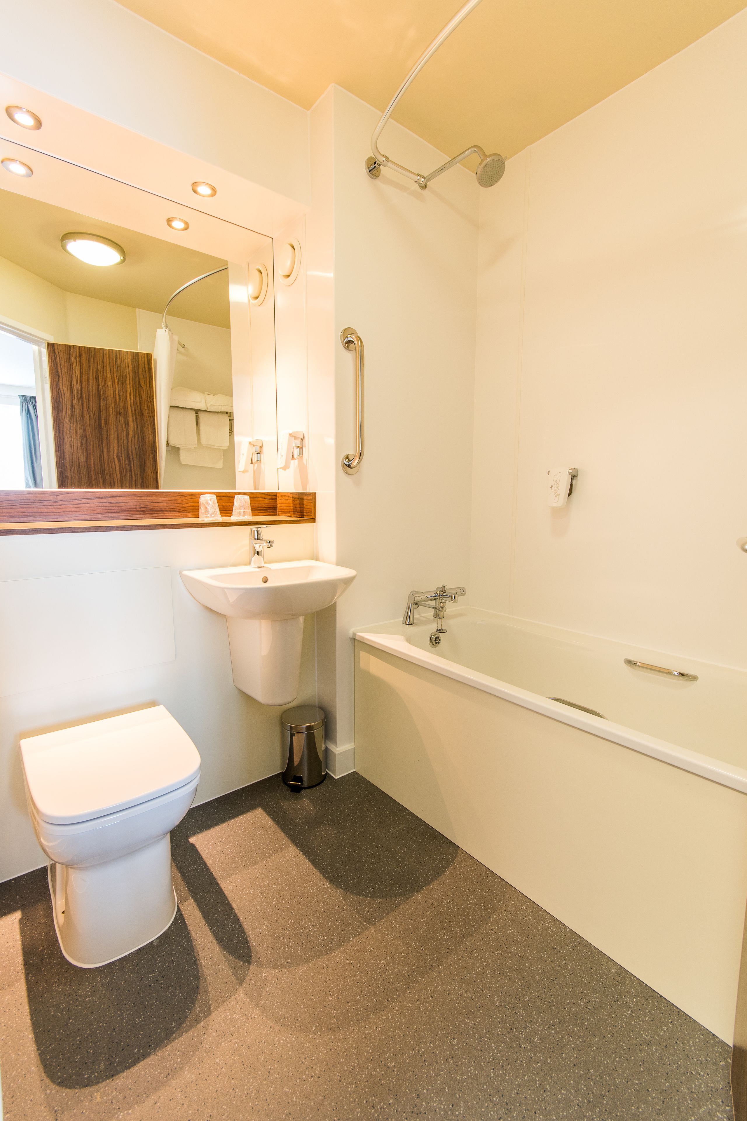 A modern bathroom with a toilet, sink, and bathtub.