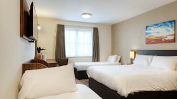 Habitación de hotel con dos camas, un escritorio, una silla y un cuadro en la pared.