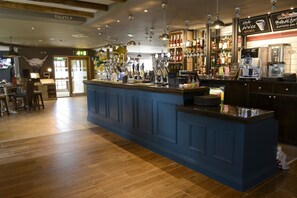 A bar area with a blue counter, multiple taps, and a coffee machine. - Highland Gate, Stirling by Marston's Inns (Stirling)