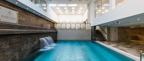 Una piscina interior moderna con una pared de madera y un cartel que dice "FONTANA SPA".
