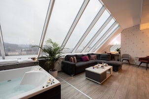 Ein modernes Wohnzimmer mit großem Oberlicht, einer Couch, einem Couchtisch und einer Badewanne.