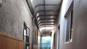 A corridor with wooden flooring, a fire extinguisher, and a potted plant. - Seasons B&B (Liuqiu)