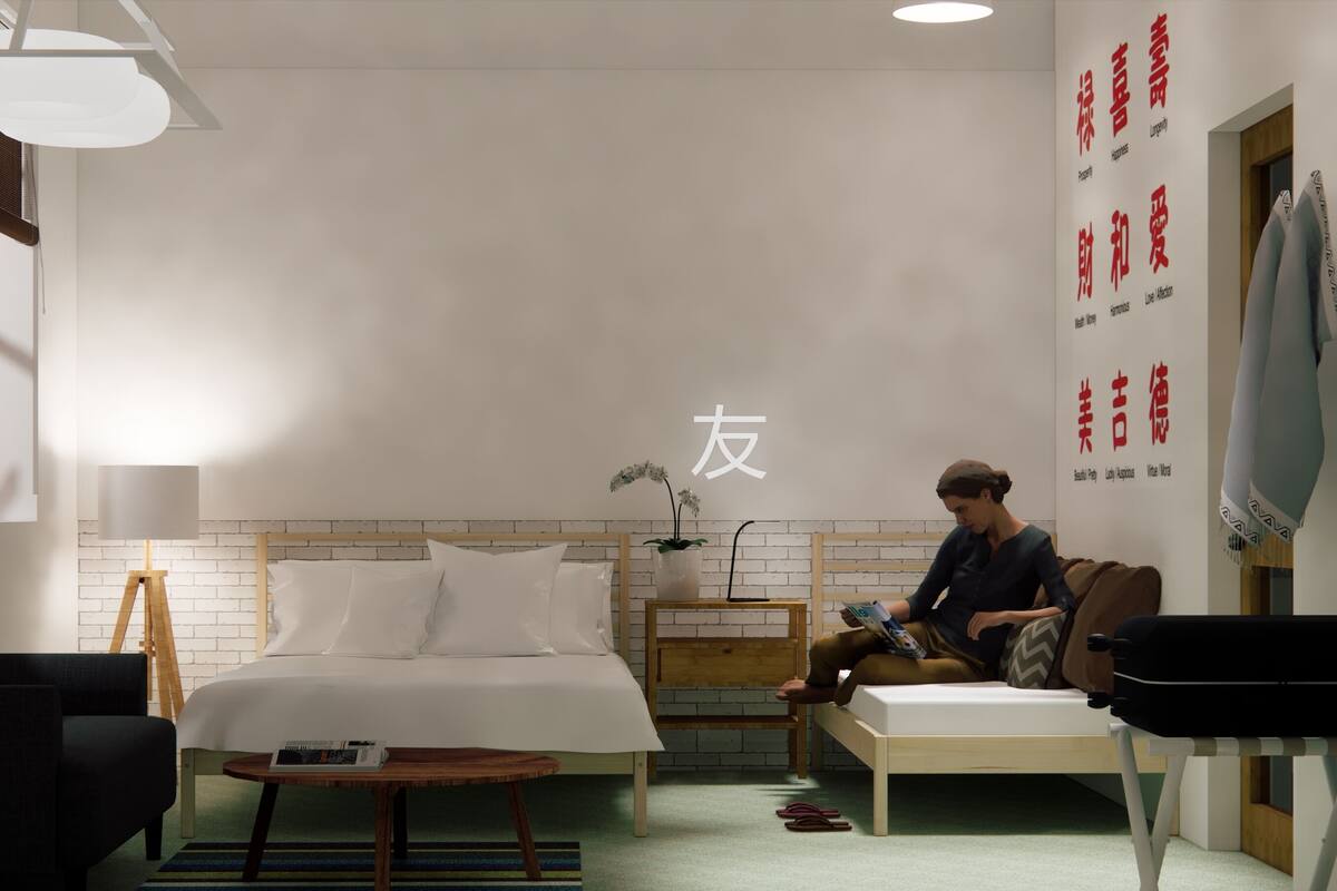 A modern hotel room with a bed, a reading chair, a bedside table, and a wall-mounted TV.