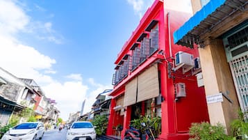 Stroll through historic streets lined with charming buildings, including a prominent red structure with a balcony.