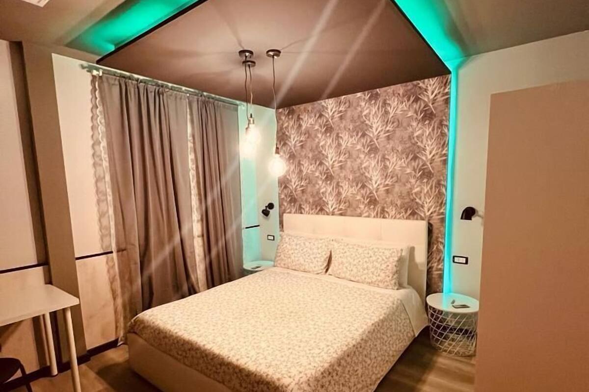 Un dormitorio con cama, escritorio y silla.