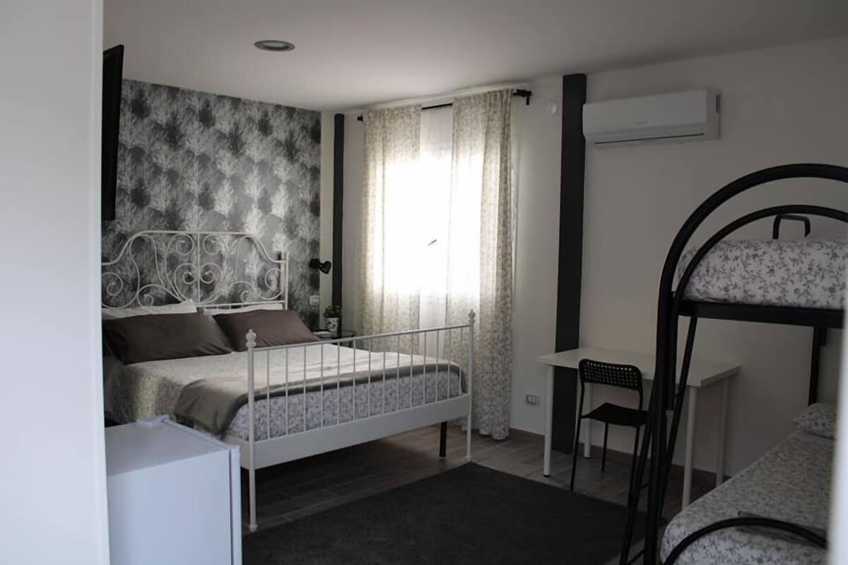 Un dormitorio con una cama, un escritorio, una silla y una litera.