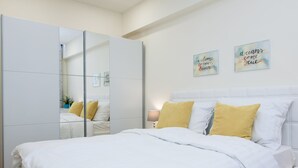 A bedroom with a bed, white bedding, a bedside lamp, and two motivational wall art pieces. - Luxury Main Square Apartments (Zagreb)