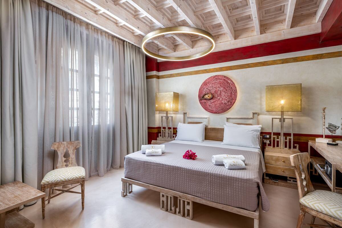 Une chambre d’hôtel avec un grand lit, deux tables de chevet, un bureau et une chaise.