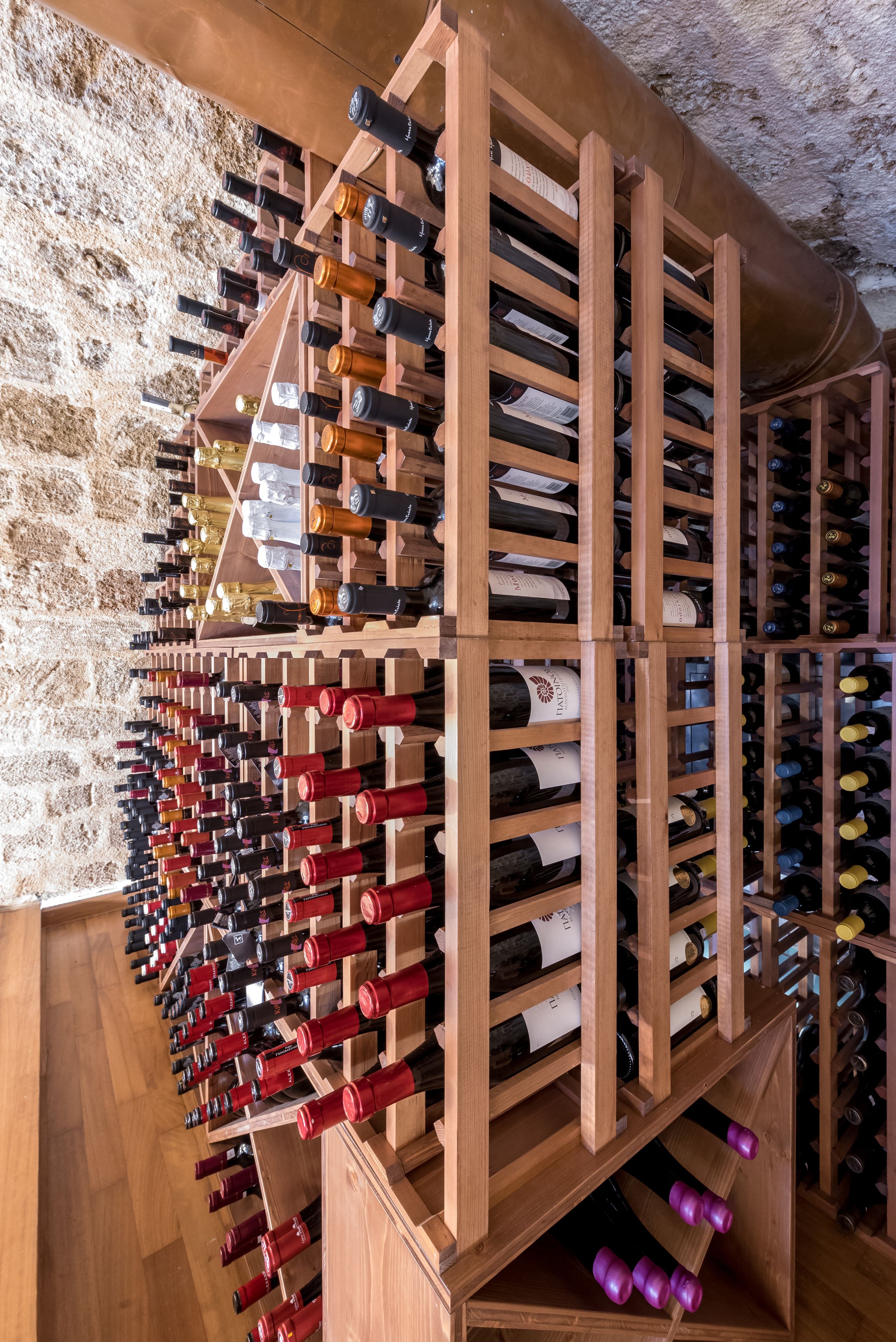 A wine cellar with wooden racks holding numerous wine bottles.