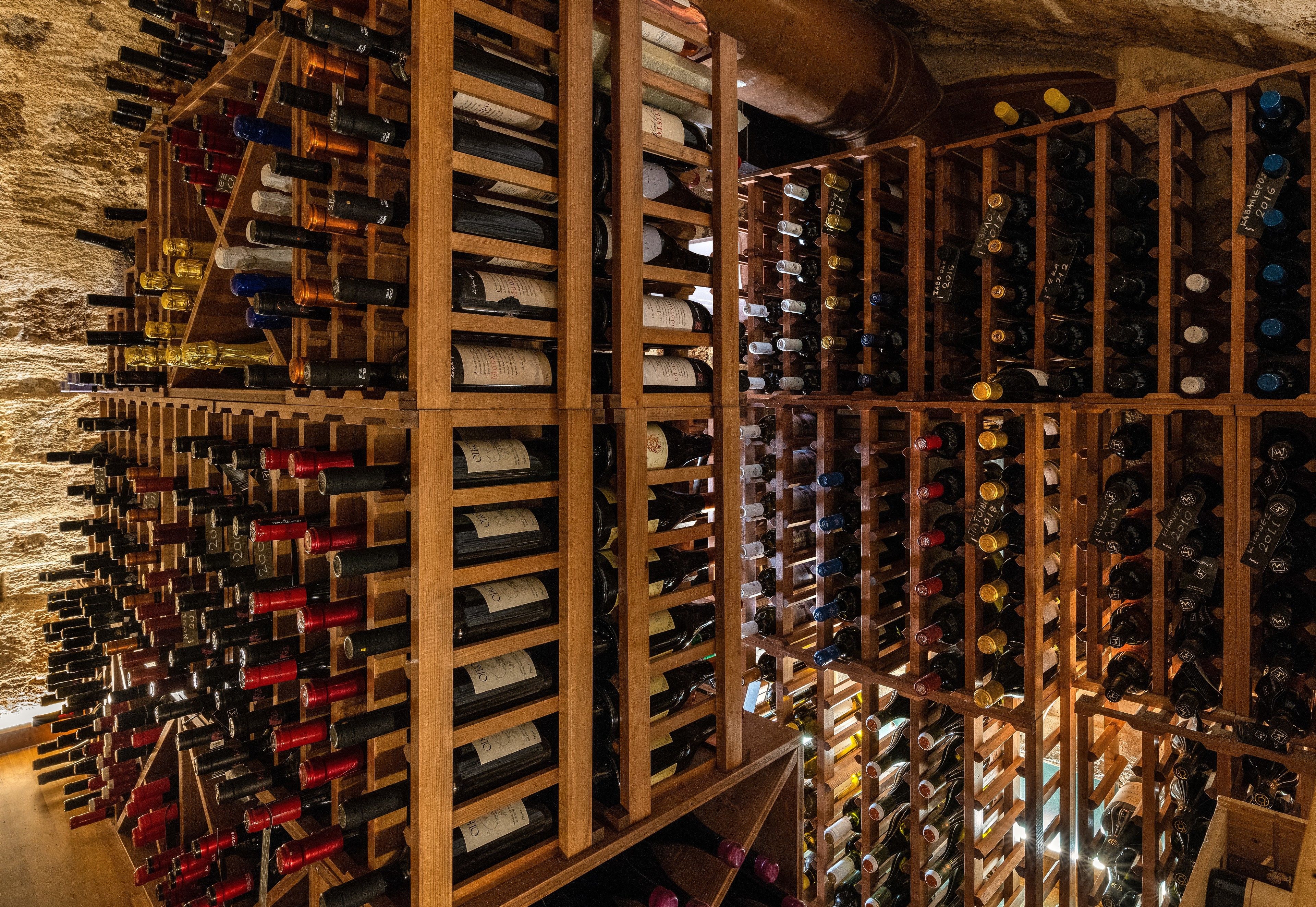 A wine cellar with wooden racks holding numerous wine bottles.