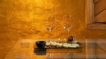 A table with two wine glasses, a bowl, and a plate with cheese and crackers.