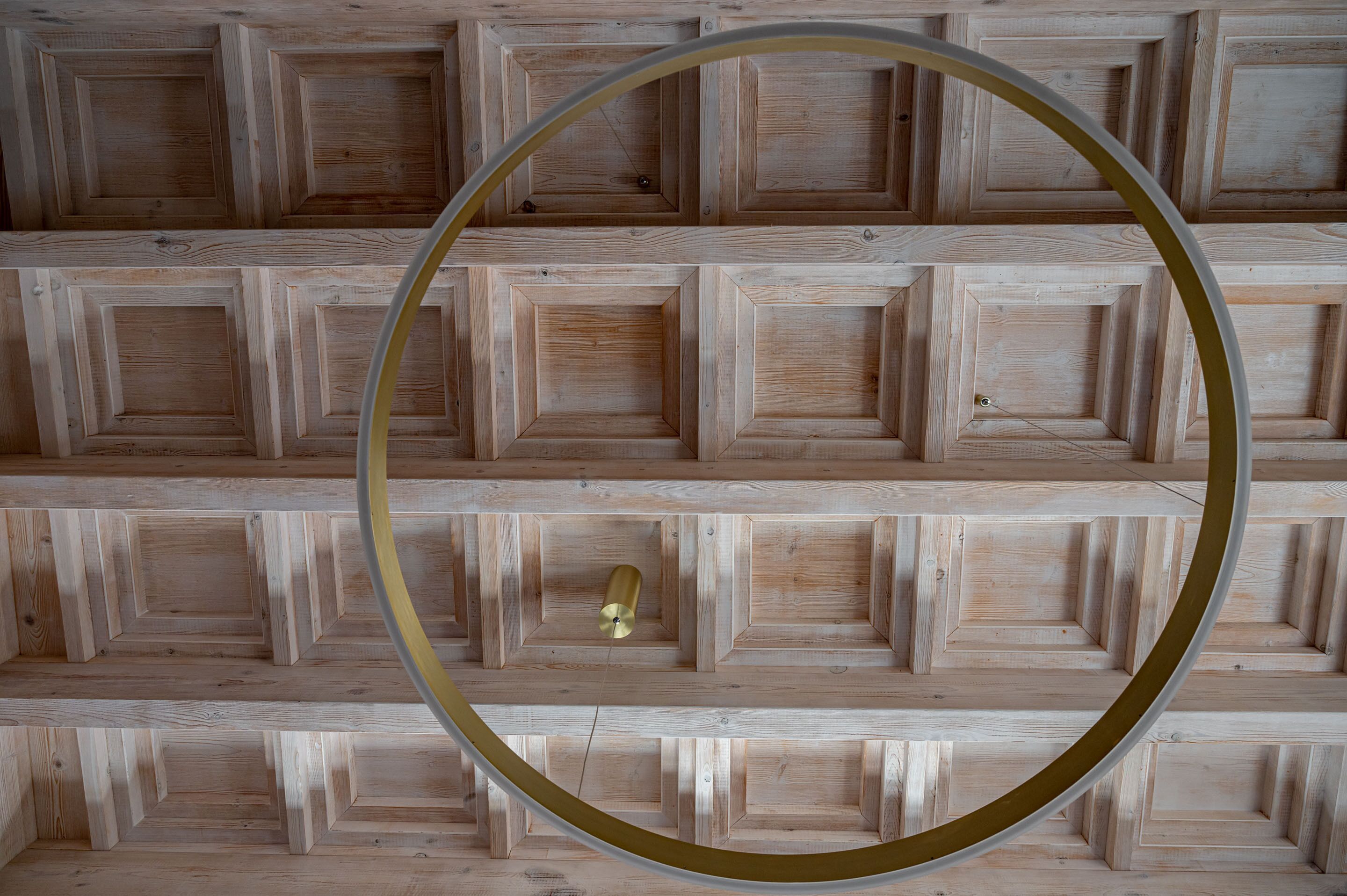 Un sostre amb panells de fusta i una estructura metàl·lica circular.