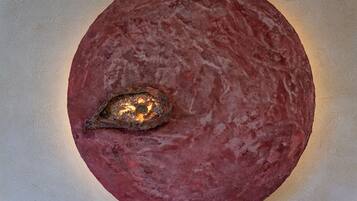 A circular, textured wall with a metallic object embedded in it.