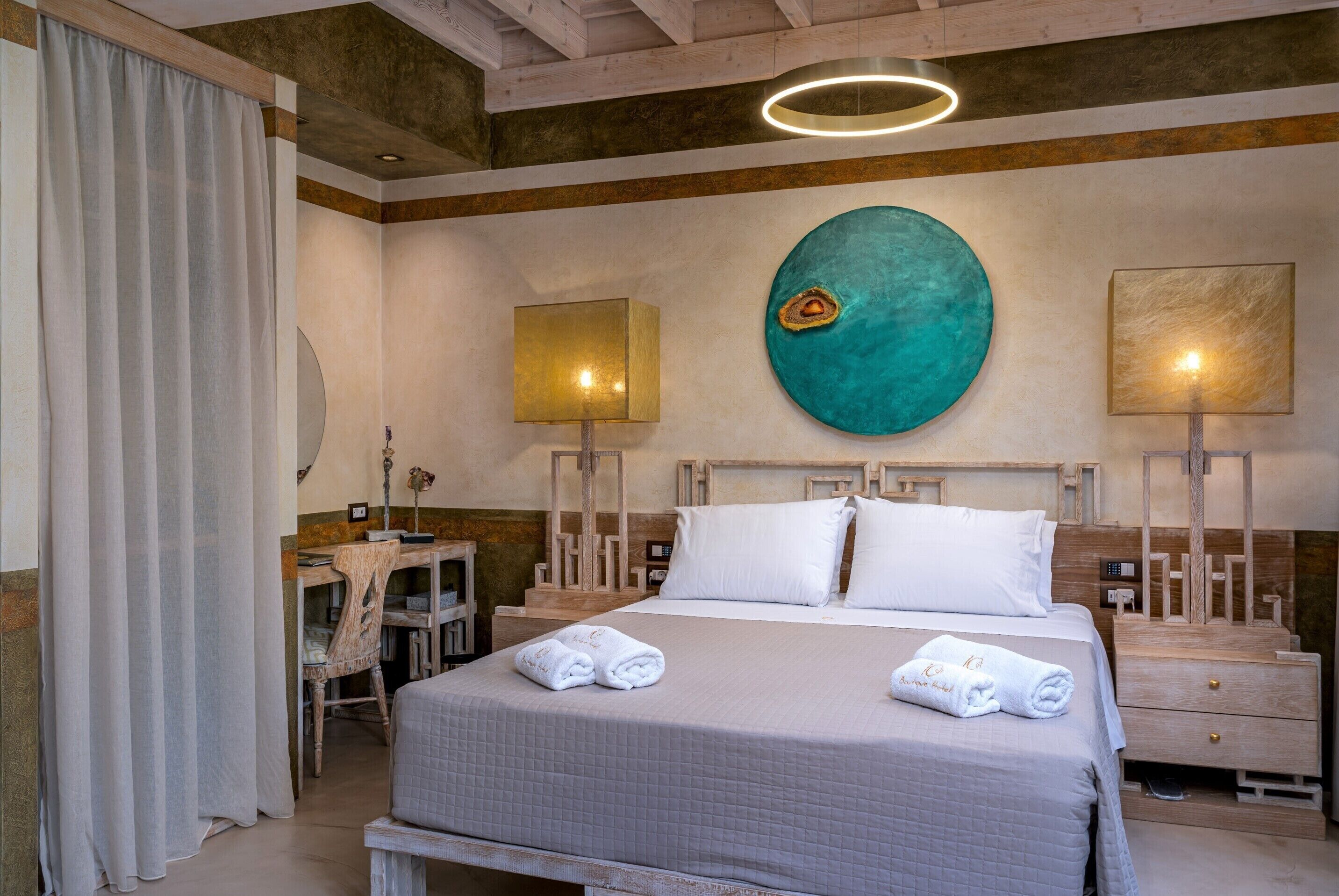 Una habitación de hotel con una cama, dos mesitas de noche, un escritorio y una silla.