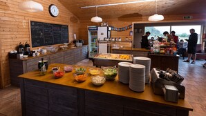 Un espace buffet proposant différents plats et une horloge au mur.