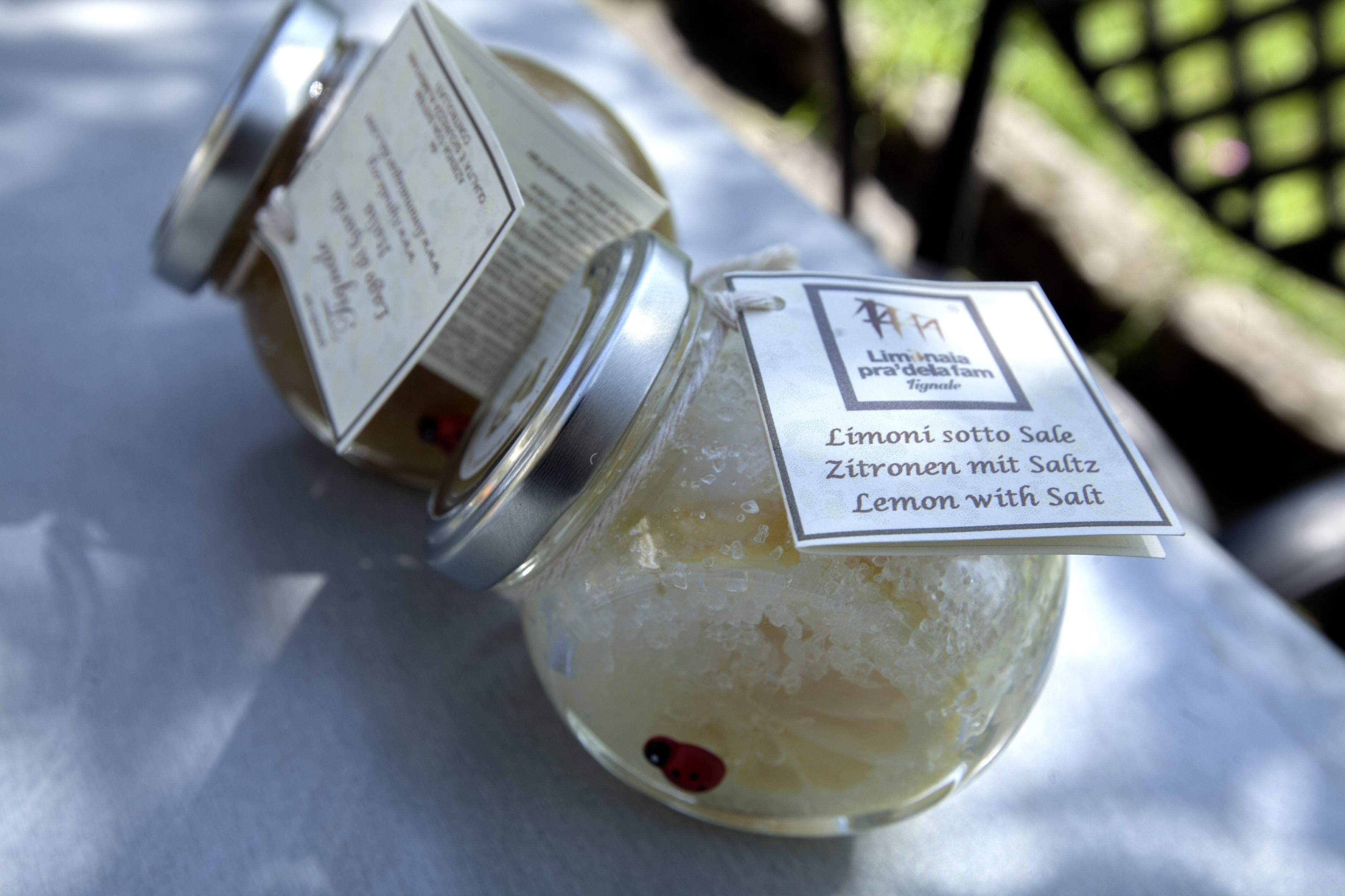 Two glass jars with labels containing lemon slices and salt.