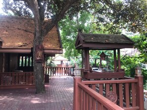 A wooden deck with a gazebo, a building with a tiled roof, and a tree. - Kawila126 Villa (Chiang Mai)