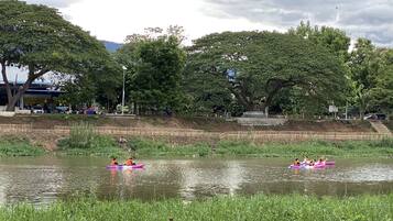 Un parque con un estanque tranquilo, bancos y árboles.