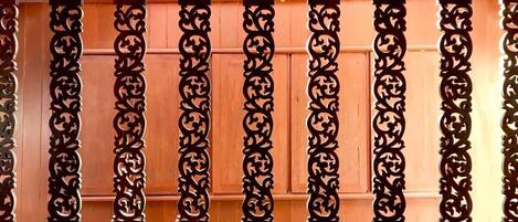 A row of ornate, dark-colored wooden panels with intricate carvings, likely part of a building's exterior.