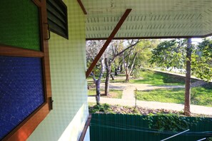 A covered outdoor area with a view of a grassy park and trees. - Kawila126 Villa (Chiang Mai)
