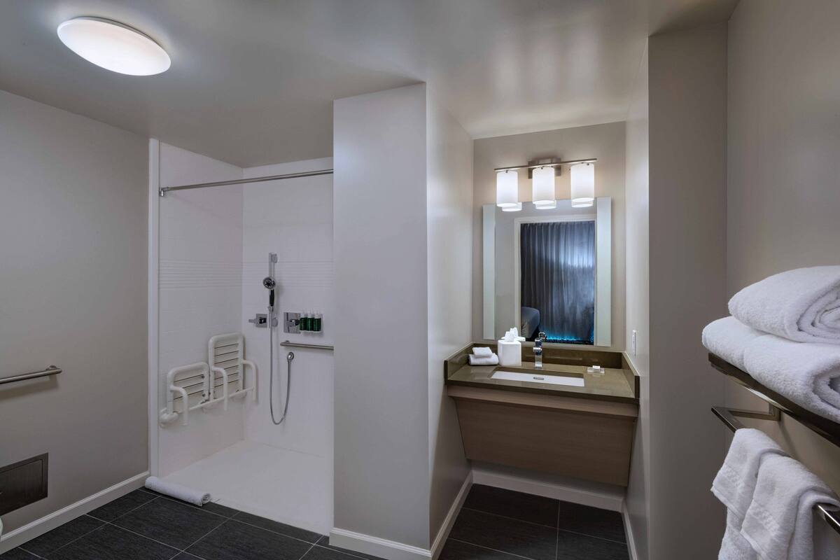 A modern bathroom with a shower, toilet, and sink.