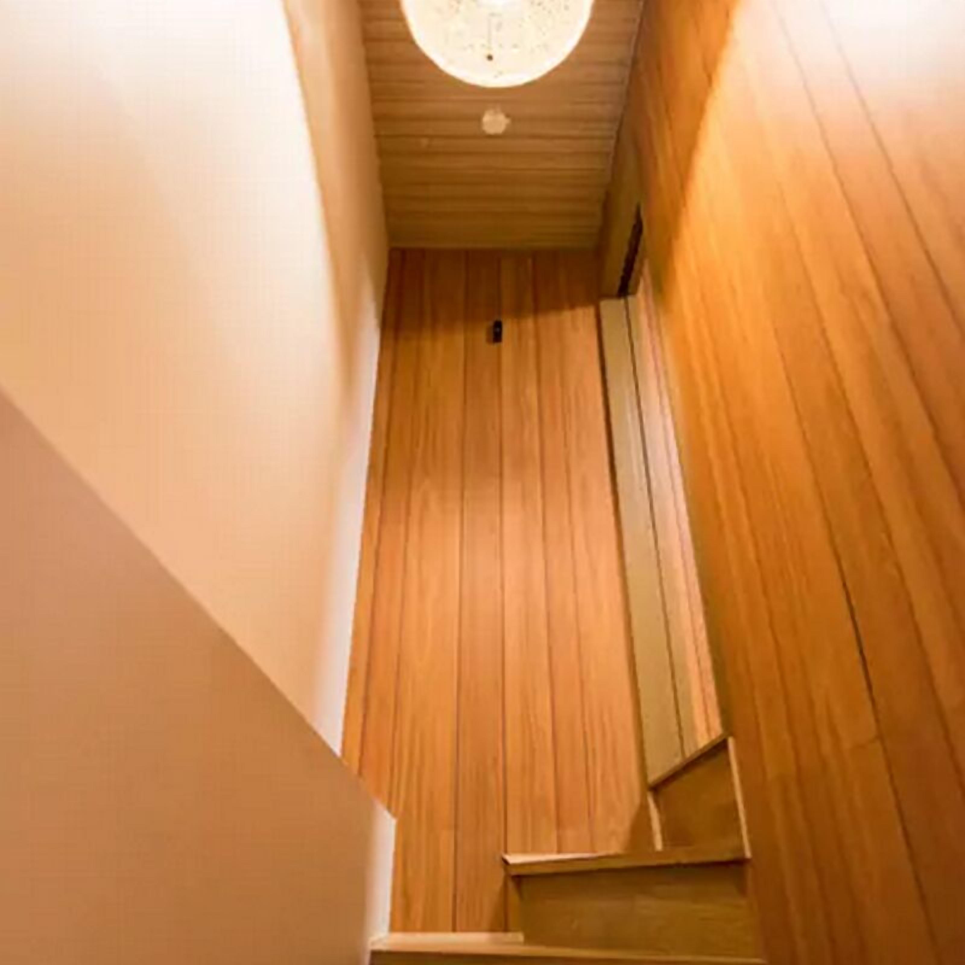 Een houten trap met een plafondlamp.