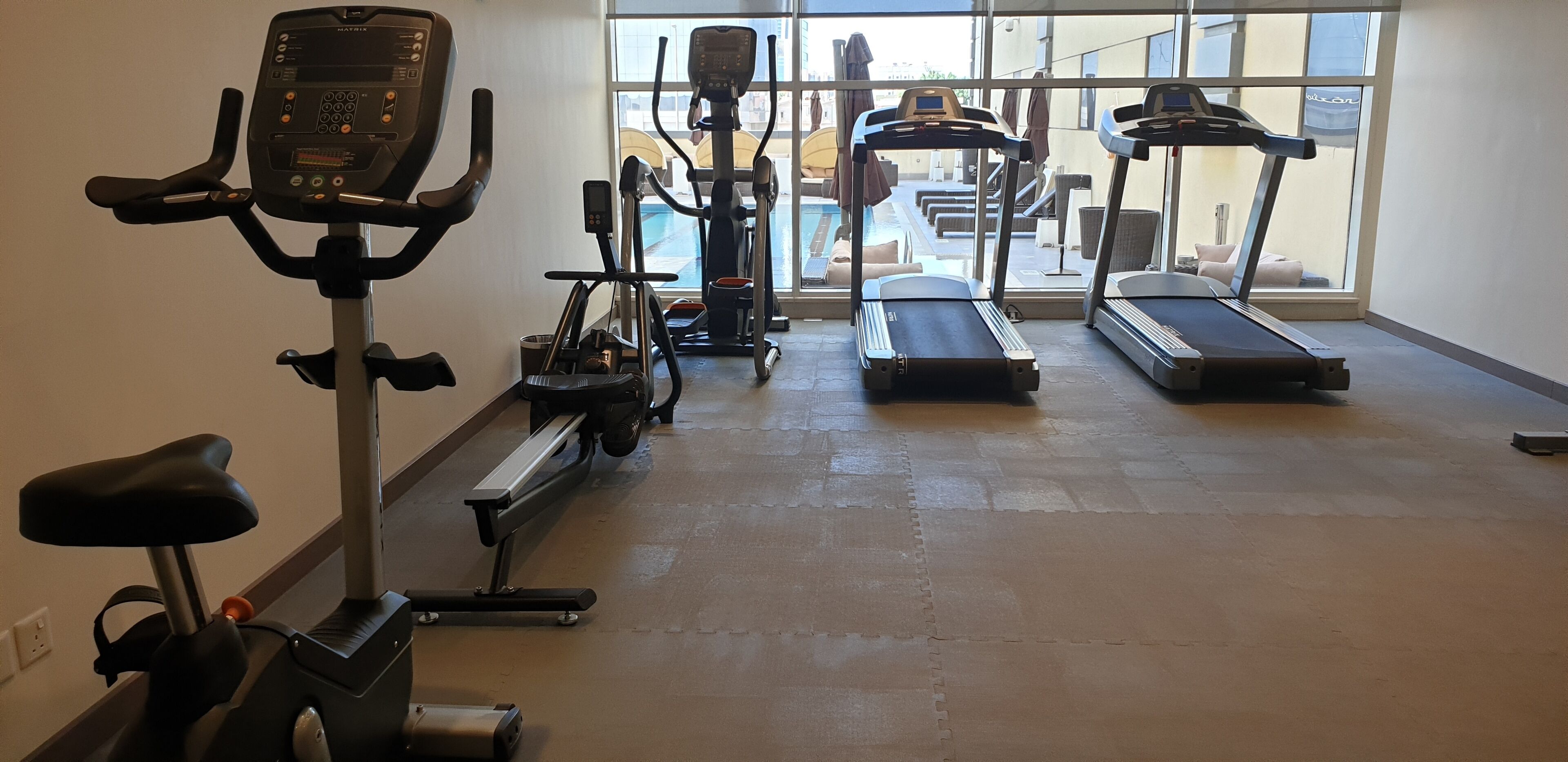 A gym with cardio equipment including a stationary bike, elliptical, and treadmills.